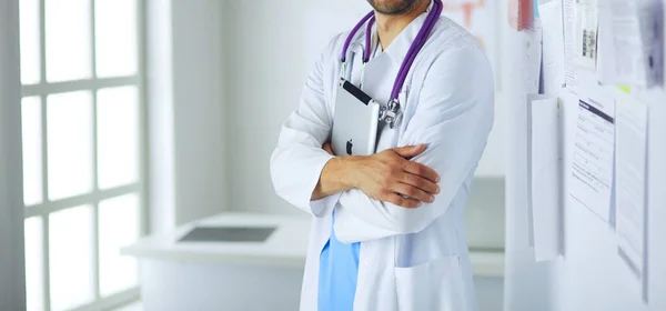 Jovem e confiante retrato médico masculino em pé no consultório médico. — Fotografia de Stock