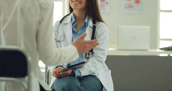 Docteur et patient discutant de quelque chose assis à la table. Médecine et soins de santé concept — Photo