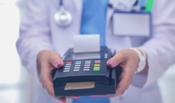 Le docteur tient le terminal de paiement entre les mains. Payer pour les soins de santé. Docteur. — Photo