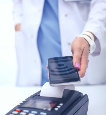 Doktor ödeme terminalini elinde tutuyor. Sağlık hizmetlerinin parasını ödüyorum. Doktor.