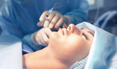 Ameliyat odasında arka planda erkek cerrah var.