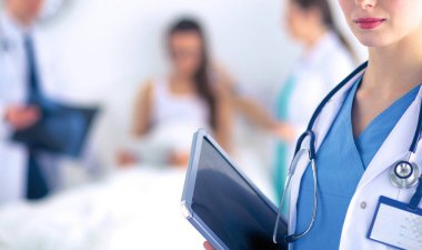 Kadın doktor hastanede dosyayla bekliyor.