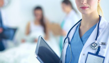 Kadın doktor hastanede dosyayla bekliyor.