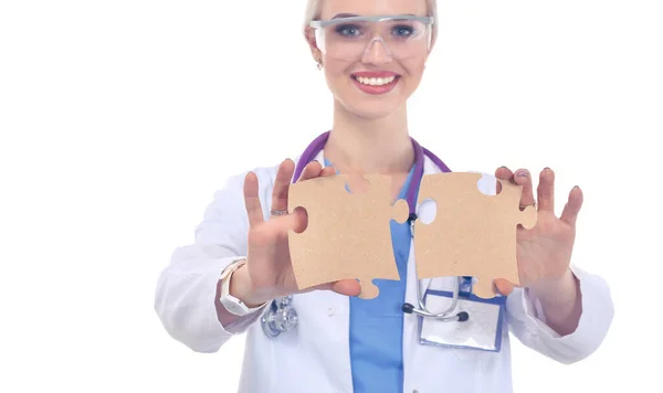 Woman doctor holding two connecting puzzle pieces — Stock Photo, Image