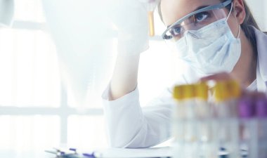 Hastanedeki kan örneğini analiz eden güzel bir kadın laboratuvar asistanı portresi.