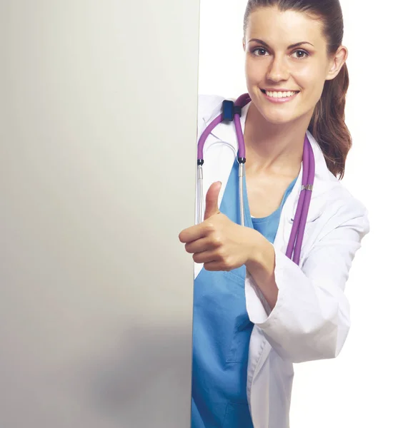 Fiatal orvos nő sztetoszkóppal áll asztal mellett, elszigetelt fehér háttér — Stock Fotó
