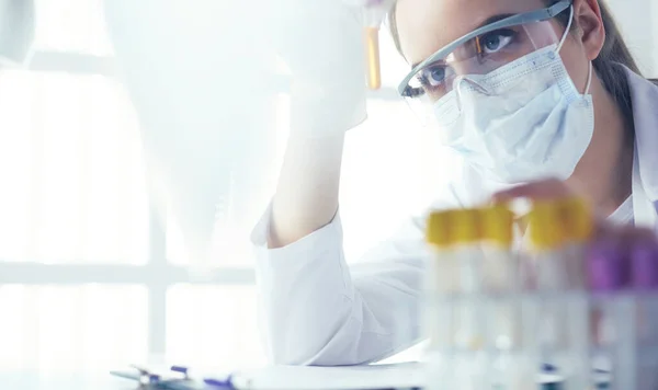 Retrato de una asistente de laboratorio bastante femenina analizando una muestra de sangre en el hospital — Foto de Stock