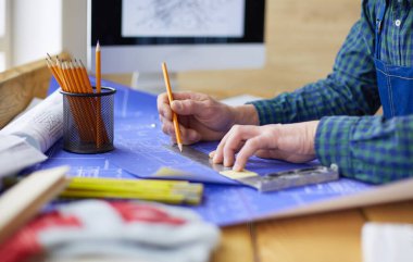 Ofisteki çizim masasında çalışan mimar