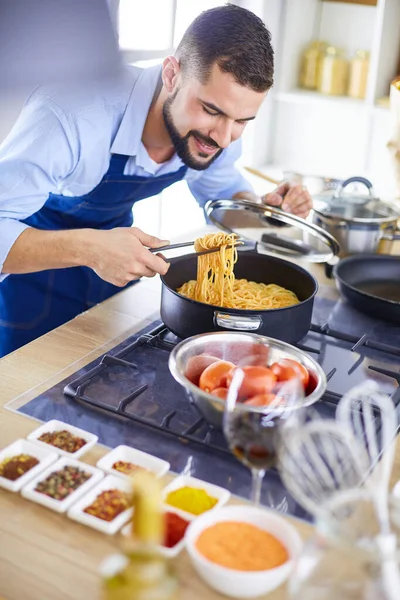 Uomo che prepara cibo delizioso e sano nella cucina di casa — Foto Stock