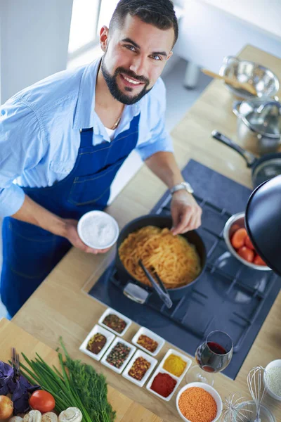 Uomo che prepara cibo delizioso e sano nella cucina di casa — Foto Stock