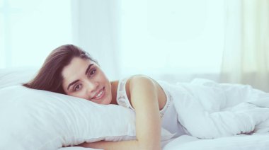 Güzel bir kadın yatağında uzanıyor.