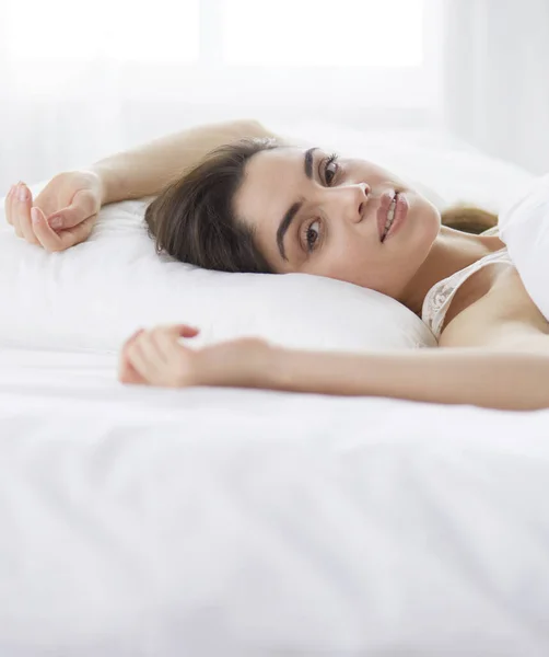 Mulher bonita deitada em sua cama em casa — Fotografia de Stock