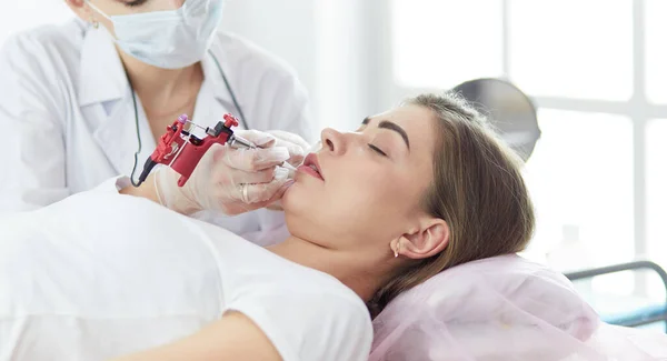 A young girl having red lips permanent makeup, micropigmentation — Stock Photo, Image