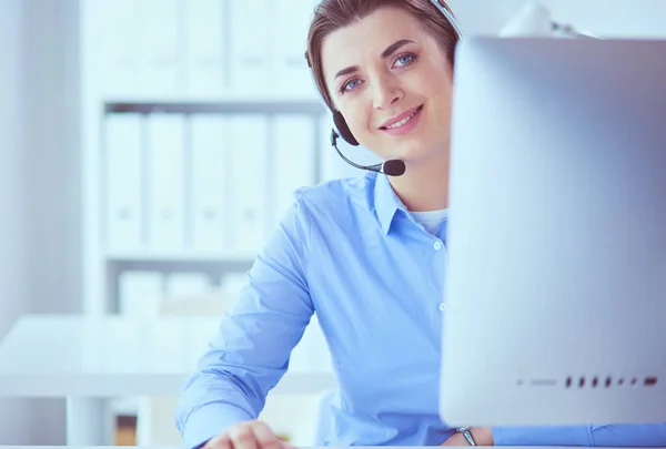 Mujer bastante joven y seria que trabaja como operador de telefonía de apoyo con auriculares en la oficina — Foto de Stock