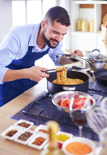 家のキッチンでおいしいと健康食品を準備する男 — ストック写真