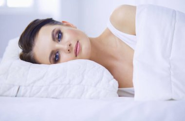 Genç ve güzel bir kadın yatakta yatıyor..