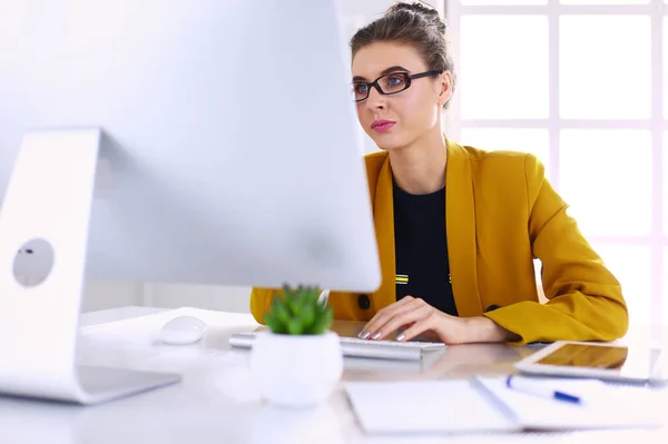 Junge selbstbewusste Geschäftsfrau arbeitet am Schreibtisch und tippt mit dem Laptop — Stockfoto