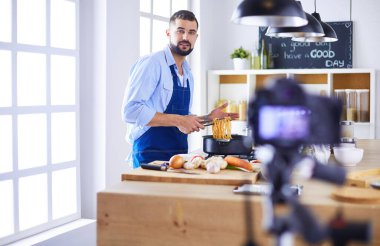 Mutfak arka planında poşet dolusu erzak tutan adam. Alışveriş ve sağlıklı gıda konsepti