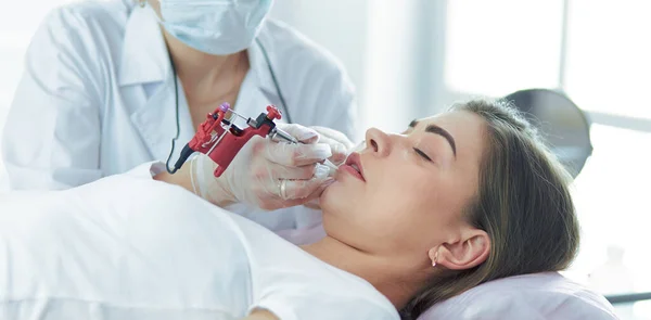 A young girl having red lips permanent makeup, micropigmentation — Stock Photo, Image