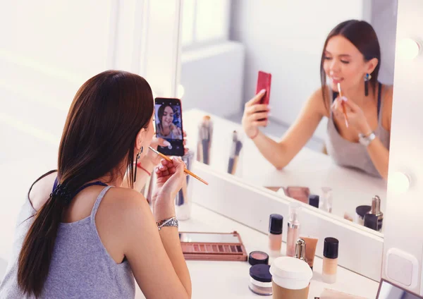 Beauty Blogger filma makeup handledning med smartphone framför spegeln — Stockfoto