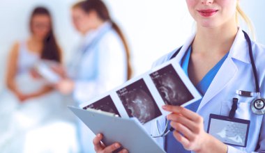 Kadın doktor hastanede steteskopla dikiliyor.