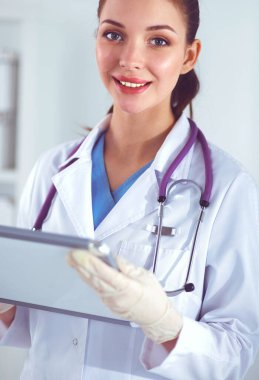 Kadın doktor hastanede dosyayla bekliyor.