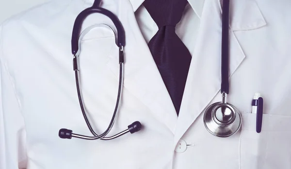 Retrato de um médico do sexo masculino com laptop sentado na mesa no consultório médico. — Fotografia de Stock