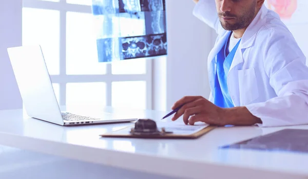 Guapo médico está hablando con una joven paciente y haciendo — Foto de Stock