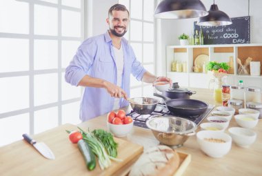 Adam ev mutfağında lezzetli ve sağlıklı yemekler hazırlıyor.