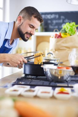 Adam ev mutfağında lezzetli ve sağlıklı yemekler hazırlıyor.