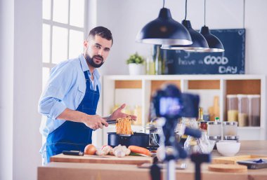 Mutfak arka planında poşet dolusu erzak tutan adam. Alışveriş ve sağlıklı gıda konsepti