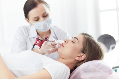 Kırmızı dudaklı genç bir kız kalıcı makyaj, mikro pigmentasyon