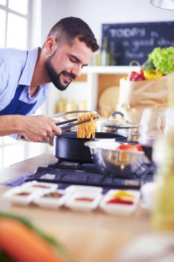 Adam ev mutfağında lezzetli ve sağlıklı yemekler hazırlıyor.