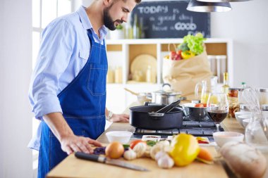 Adam ev mutfağında lezzetli ve sağlıklı yemekler hazırlıyor.