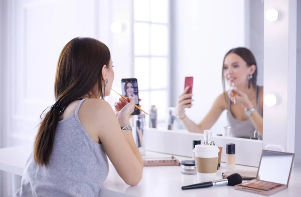 Beauty-Bloggerin filmt Make-up-Anleitung mit Smartphone vor Spiegel — Stockfoto