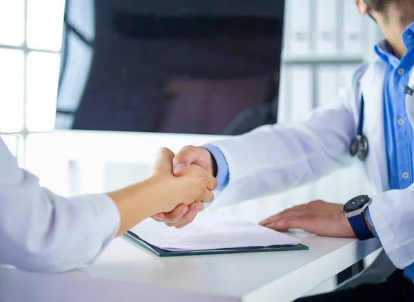 Doctor shaking hands to patient in the office at desk — Stock Photo, Image