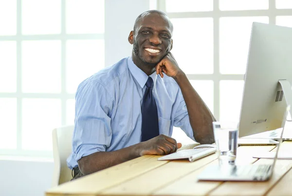 Afrikansk amerikansk affärsman på headset arbetar på sin bärbara dator — Stockfoto