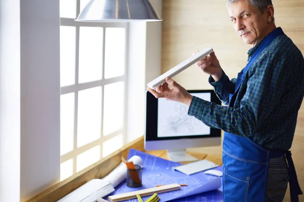 Ofisteki çizim masasında çalışan mimar