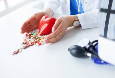 Masada kırmızı kalbi ve steteskopu olan kardiyolog.