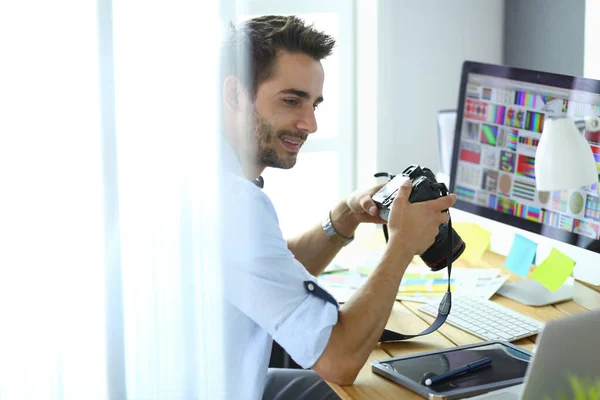 Retrato de jovem designer sentado no estúdio gráfico na frente de laptop e computador enquanto trabalhava online. — Fotografia de Stock