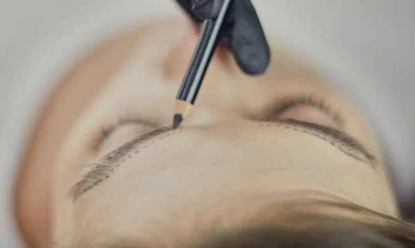 Cosmetologo che applica trucco permanente sulle sopracciglia — Foto Stock