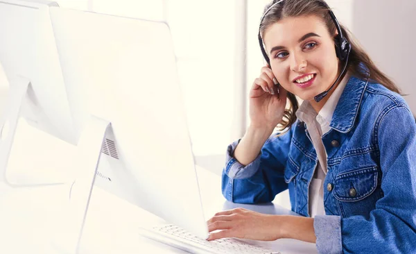 Femme d'affaires souriante avec casque à l'aide d'un ordinateur portable au bureau au travail — Photo