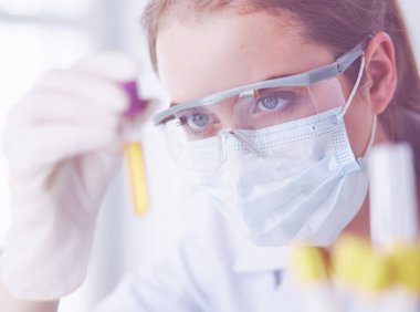 Modern laboratuvar veya hastanede plastik tıbbi tüplerle çalışan araştırmacı, doktor, bilim adamı veya laboratuvar asistanı