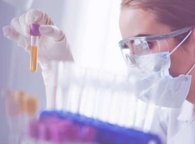 Laboratuvarda sıvı yeşil çözeltiye bakan bir tıbbi veya bilimsel araştırmacı ya da doktor
