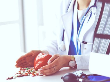 Masada kırmızı kalbi ve steteskopu olan kardiyolog.