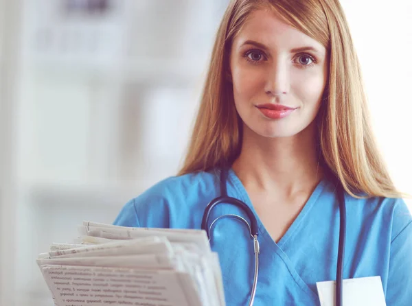 Retrato de médico mulher com pasta no corredor do hospital — Fotografia de Stock