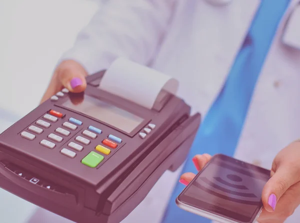 Doctor is holding payment terminal in hands. Paying for health care. Doctor