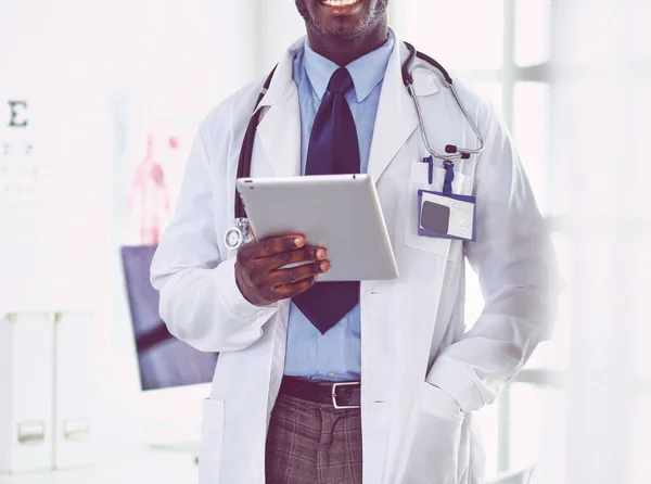 Male black doctor worker with tablet computer standing in hospital