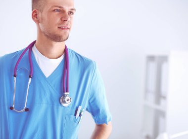 Steteskoplu doktor ayakta, çapraz kollu, beyaz arka planda izole.