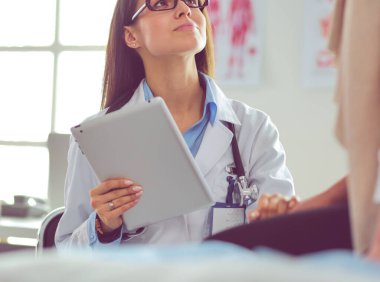 Doktor ve hasta masada otururken bir şey tartışıyorlar. İlaç ve sağlık hizmetleri kavramı
